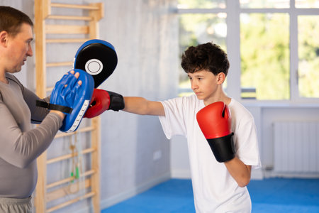 Man and boy teenager train boxing in studioの写真素材