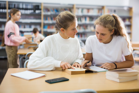 Two friends are studying in school library. Exam preparationの写真素材
