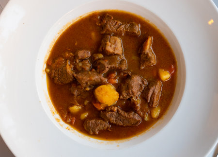 Stewed beef in sauce served with potatoes on platterの写真素材