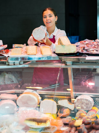 Young woman butchery worker at counterの写真素材