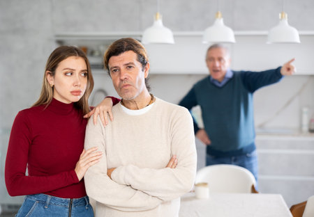 Elderly man quarreling with man and woman coupleの写真素材