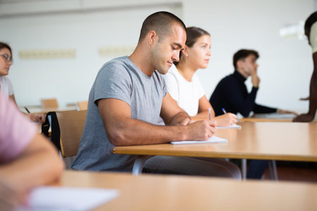 Interested focused man sitting at lesson in school for adults