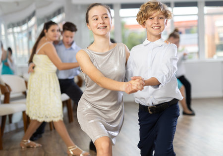 Teen boy and girl are dancing contemporary modern discofox in couple during lesson at studioの写真素材