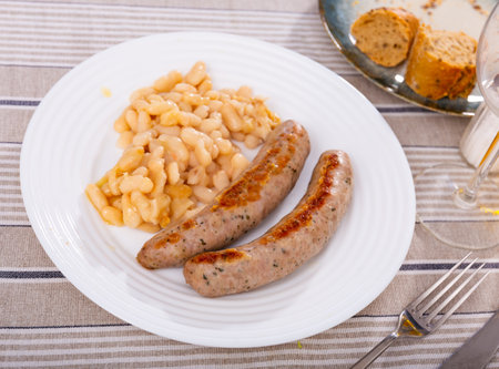 Fried botifarra sausage served with cooked white beansの写真素材