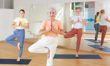 People of different ages practicing yoga, standing together in asana. Three generations conceptの写真素材