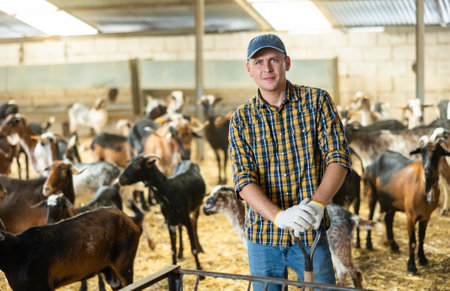 Portrait of confident male farm owner in goat penの写真素材
