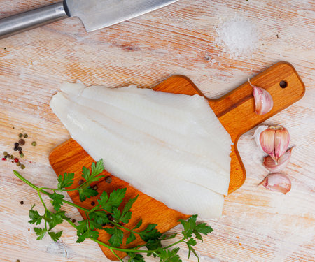 Raw halibut fillet on wooden tableの写真素材