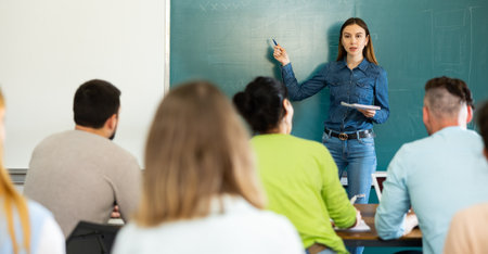 Woman teacher explaining lesson to studentsの写真素材