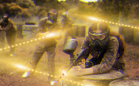 Portrait of girl in camouflage on paintball field
