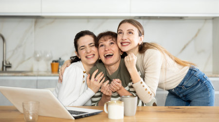 Women are sitting at computer and are immensely happy