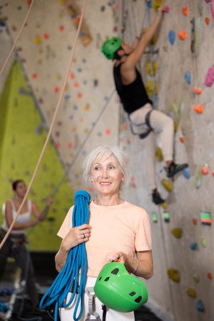 Senior confident female climber with her equipment getting ready for trainingの写真素材