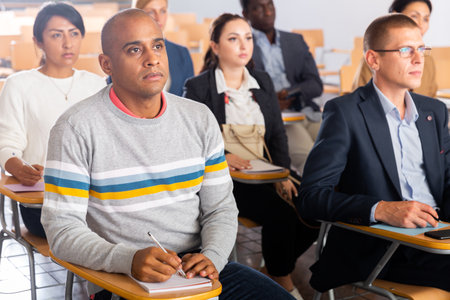 Hispanic man listening to lecturer during business trainingの写真素材