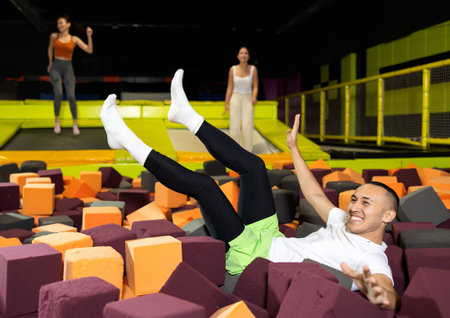 Fun in a trampoline center - after jumping on a trampoline, man fell onto soft, safe filler cubes
