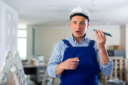 Foreman using smartphone, recording voice message
