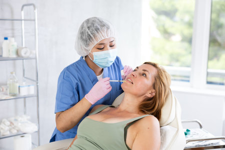 Young doctor perfoming face injecting