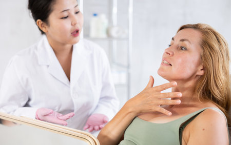 Professional cosmetologist talking about anti-aging skincare to patientの写真素材