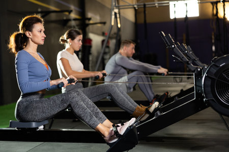 Concentrated woman working out on rowing machine in gymの写真素材