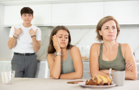 Woman sits near girl and comforts during quarrel with guyの写真素材