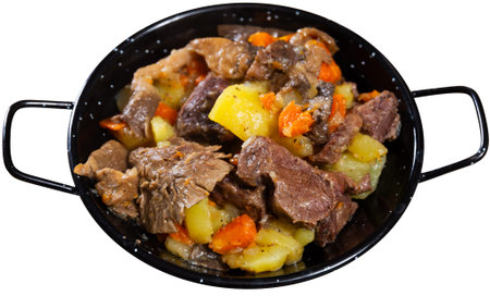 There is portion of hearty lunch on table - veal with stewed vegetables and mushroomsの写真素材