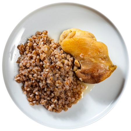 Prepared buckwheat porridge with piece of fried chicken is served on large white platter with breadの写真素材
