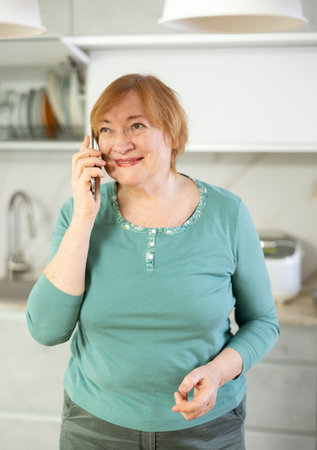 Smiling older woman talking with someone on her phoneの写真素材