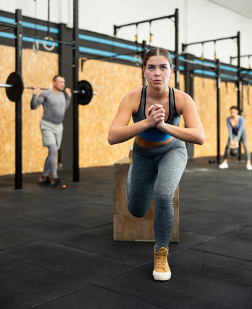 Young woman doing muscle stretching. CrossFit in group with other athletesの写真素材