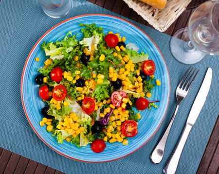 Mixed salad with corn, olives, cherry tomatoes and green lettuceの写真素材