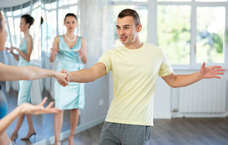 Couple in comfortable sports clothes learns boogie woogie dancing during individual lesson