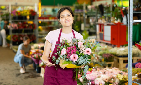 Portrait of female flower market seller with bouquets of flowersの写真素材