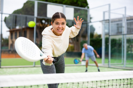 Sportive girl with racquet playing padel in courtの写真素材