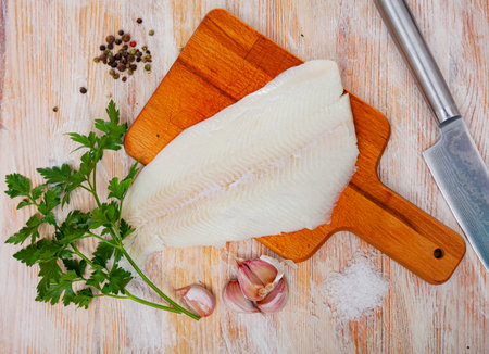 Raw halibut fillet on wooden tableの写真素材