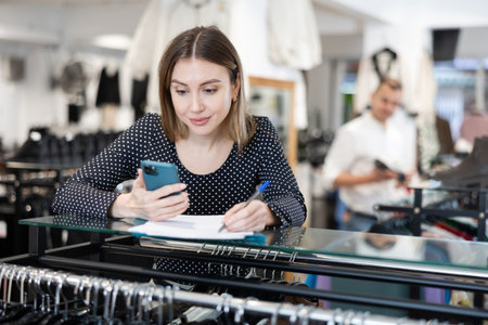 Young woman signing document in clothing store