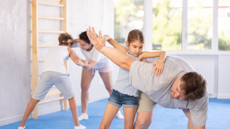 Preteen girl sparring with father during self-defense trainingの写真素材