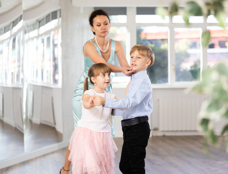 Teacher rearrange dancers pose during pair ballroom dancing lesson.の写真素材