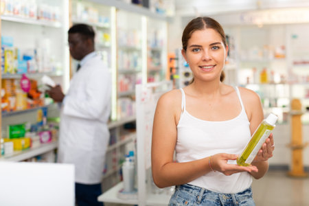 Teenager girl choosing haircare products in drugstoreの写真素材