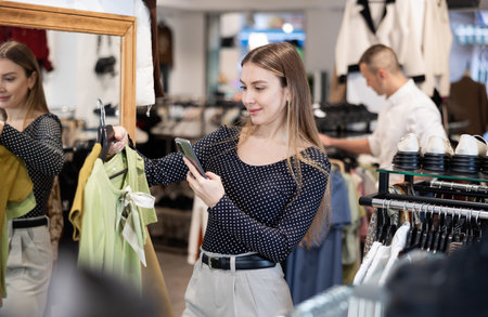 Young woman makes video call and chooses blouseの写真素材