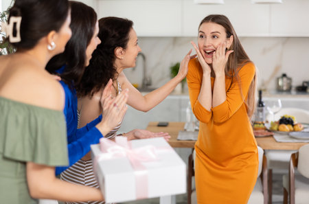 Delighted young woman receiving besties at birthday bashの写真素材