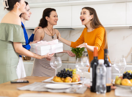 Group of women greeting each other and giving giftの写真素材