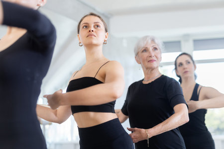 Group of women stand in position at ballet barreの写真素材