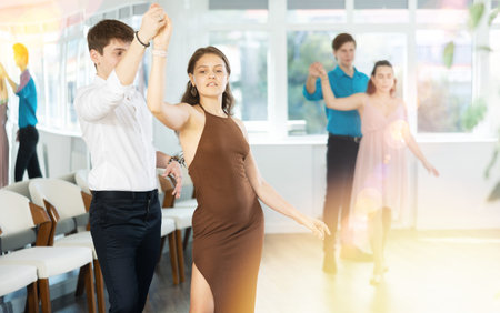 Hispanic guy practicing sensual bachata with girl in dance class