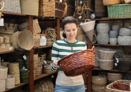 Woman looks at wicker basket in store.の写真素材