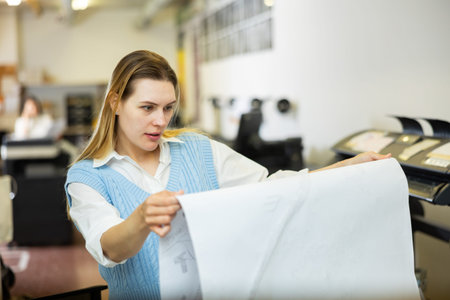 Worker in a printing and press centar check print quality