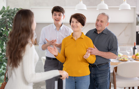 Parents and son joyfully greet their daughter and sister, who came from far awayの写真素材