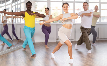 European girl with team of like-minded multinational people learn to elements of electro dance