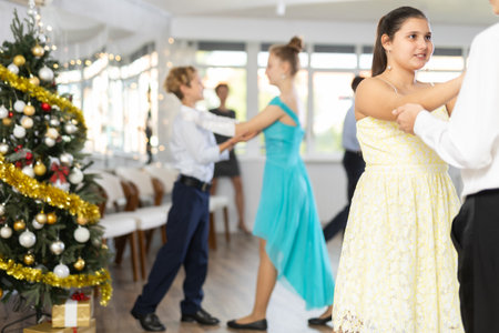 Teenage girl dancing ballroom dance with boy during New Year partyの写真素材