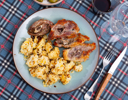 Fried fatty and juicy lamb and vegetable side dish of cauliflower with wine and olivesの写真素材
