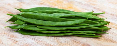 Green beans pods on a wooden surfaceの写真素材