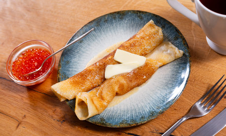 Freshly baked pancakes with red grainy salmon caviar and butter. Traditional Russian holiday dish...