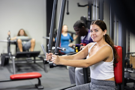Sporty woman works on special simulator for development of pectoral musclesの写真素材