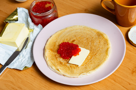 On plate - ruddy soft pancakes with butter and fresh-grain caviarの写真素材